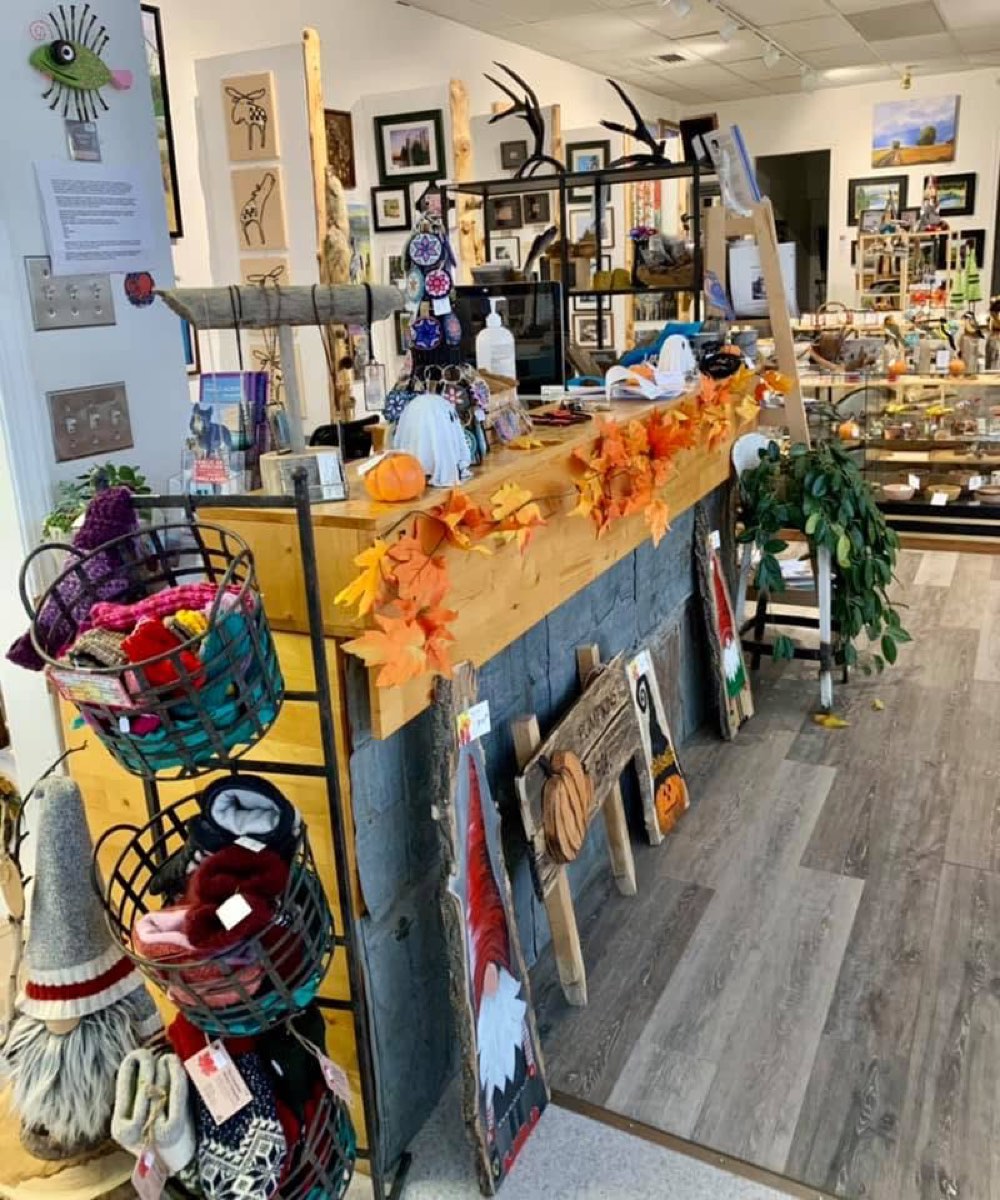 Gallery counter with knitwear, carvings and seasonal decor at On the Avenue