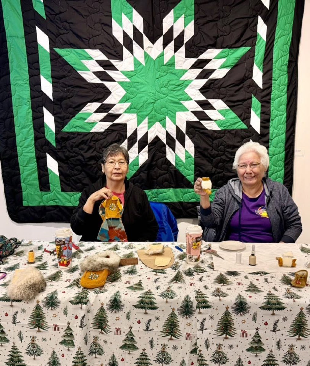 Two artists at On the Avenue with a green and black star blanket, Prince Albert, SK
