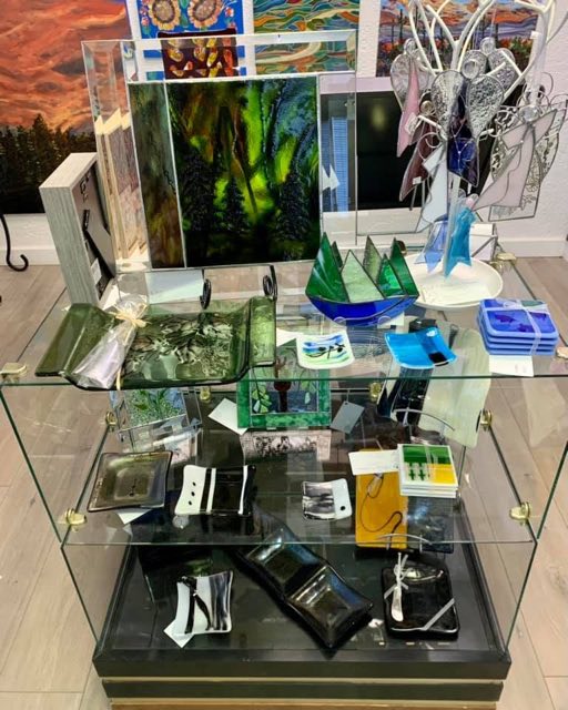 Fused glass panels, dishes and stained glass in a display case