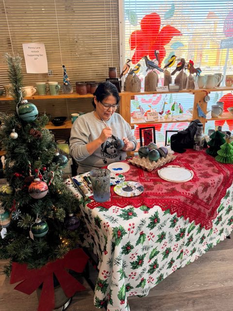 Artist hand-painting ornaments in the gallery