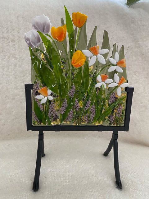Fused glass floral art on a stand at On the Avenue Gallery