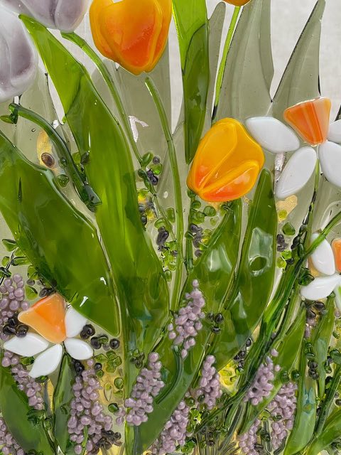 Detail of fused glass floral art with tulips and daffodils